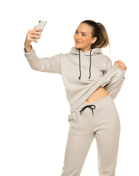 Piękna Młoda Kobieta Dresie Robi Selfie Białym Tle Studio — Zdjęcie stockowe