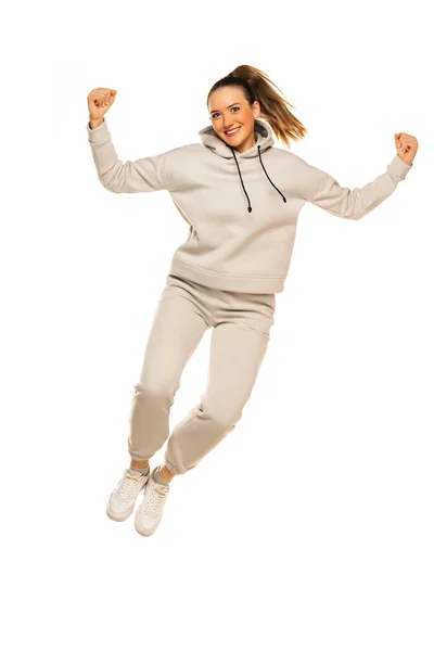 Eine Junge Glückliche Frau Grauen Trainingsanzug Springt Studio Vor Weißem — Stockfoto