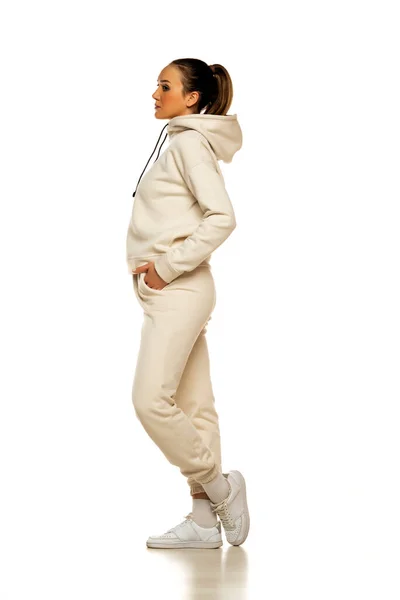 Seitenansicht Einer Jungen Frau Beigen Trainingsanzug Die Vor Weißem Hintergrund — Stockfoto