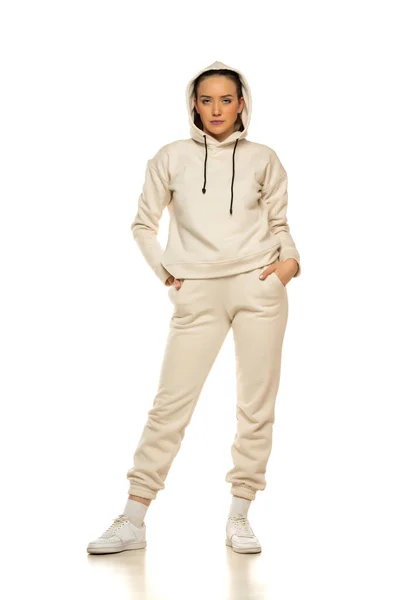 Front View Young Woman Beige Tracksuit Hood Posing White Background — стоковое фото