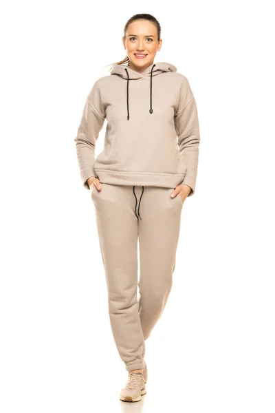 Front View Young Smiling Woman Gray Tracksuit Walking White Background — Φωτογραφία Αρχείου