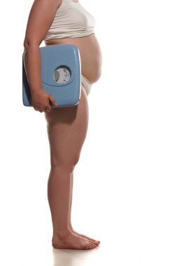 Koca şişman kadın büyük banyo terazisi taşıyor..