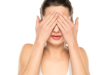 Photo of happy young woman, arm palm covering eyes toothy smile isolated on white studio background.