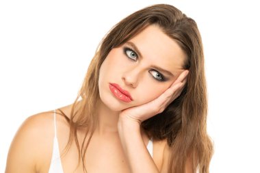 Bored tired young pretty womwn with long hair, thinking dreaming over white background.