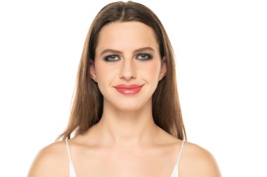 Beautiful smiling woman with make up and long hair on a white studio background.