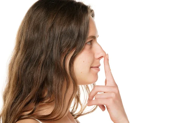 Wanita Muda Tersenyum Menyentuh Hidungnya Dengan Jarinya Pada Latar Belakang — Stok Foto