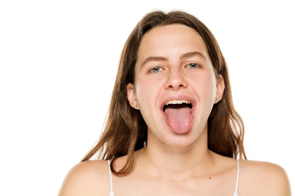 Young Woman Sticking Tongue Out White Background — Zdjęcie stockowe