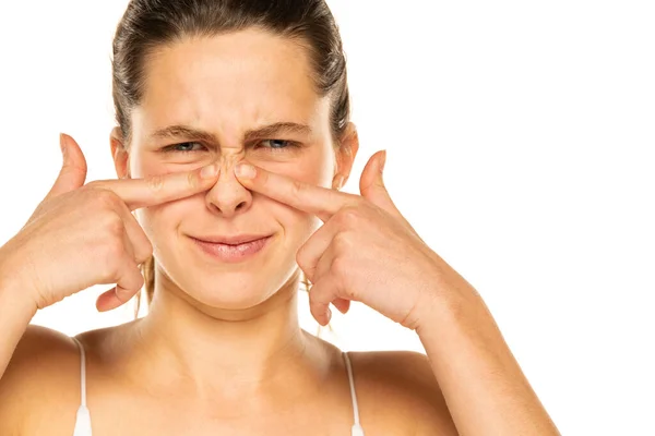 Young Woman Press Her Nose Her Fingers White Background — Fotografia de Stock