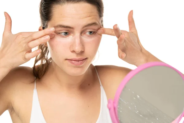Young Woman Applyes Concealer Her Eyes White Studio Background — Stok Foto