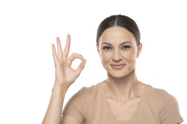 Young smiling woman with delicious gesture on white studio background.
