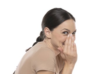 Profile image of whispering young smiling lady , posing isolated over white background.
