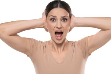 Nervous woman with hands on ears on a white background.
