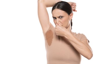 Young woman hand squeezing nose with odor sweating,Female smelling or sniffing her armpit,Bad smell.