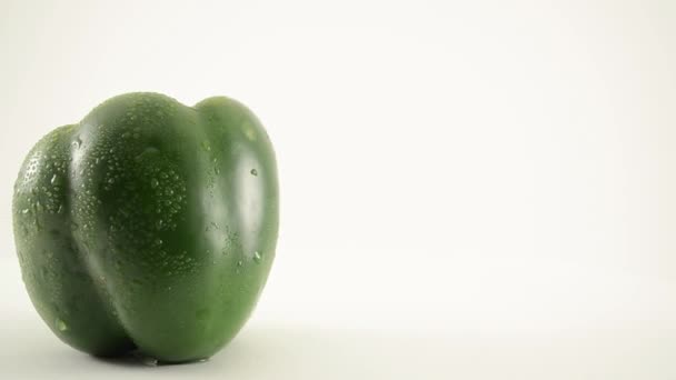 Roterande grön paprika mot vit - kranen ner — Stockvideo
