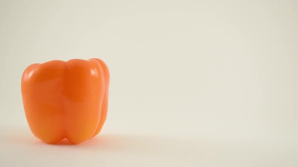 Pimienta naranja contra blanco - Grúa hacia abajo — Vídeos de Stock