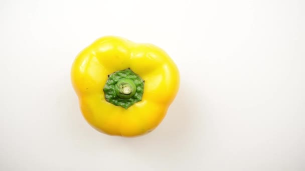 Roterande gul paprika mot vit - overhead dolly vänster — Stockvideo