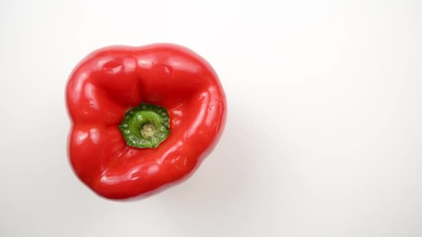 Roterende rode peper tegen Wit - overhead dolly links — Stockvideo