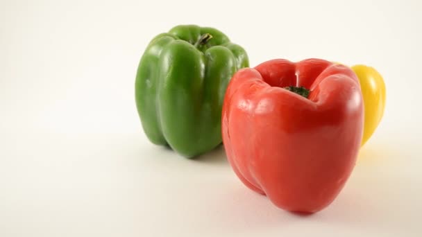 Poivrons rouges, verts et jaunes contre le blanc - Arrangement triangle - Dolly Left 