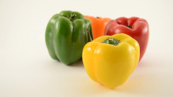 Gele, groene, rode en oranje paprika's tegen Wit - diamant arrangement - dolly links — Stockvideo