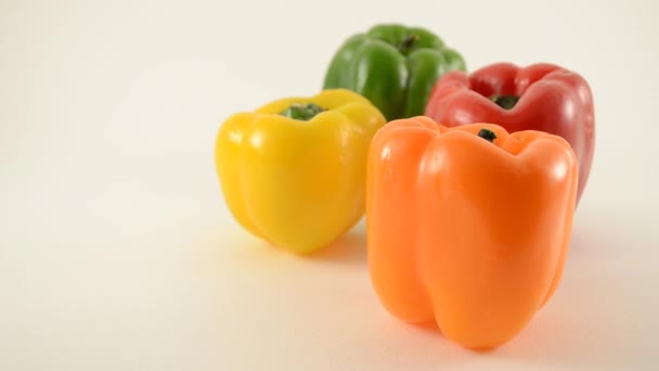 Oranje, gele, rode en groene paprika's tegen Wit - diamant arrangement - dolly links — Stockvideo