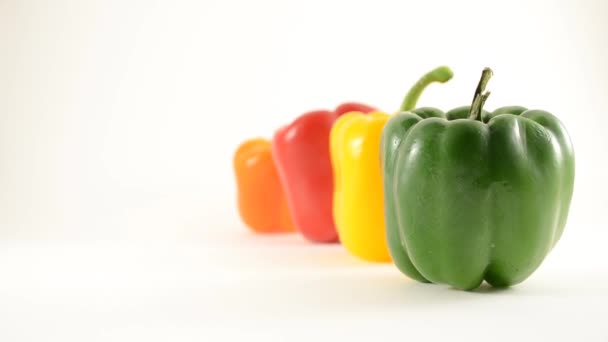Zelené, žluté, červené a oranžové papriky proti bílé - linie uspořádání - jeřáb se — Stock video