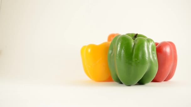 Grüne, gelbe, rote und orangefarbene Paprika gegen weiße - Rautenanordnung - Kran hoch — Stockvideo