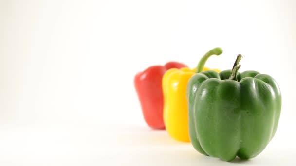 Groene, gele en rode paprika's tegen Wit - lijn arrangement - kraan naar beneden — Stockvideo