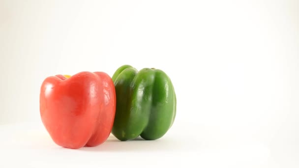 Roterende rode, groene en gele paprika's tegen Wit - kraan omhoog — Stockvideo