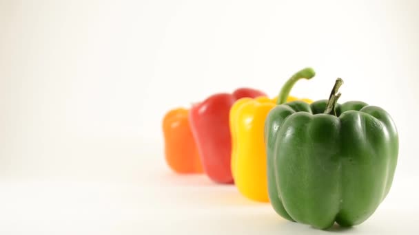 Green, Yellow, Red and Orange Peppers Against White - Line Arrangement - Crane Down — Stockvideo