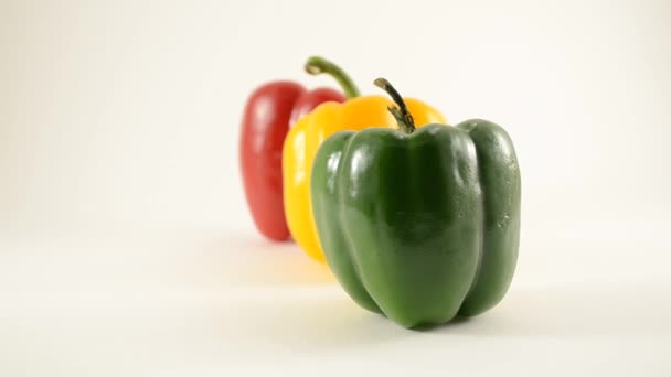Zelené, žluté a červené papriky proti bílé - linie uspořádání - dolly vpravo — Stock video