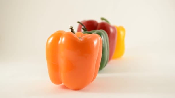 Orange, Green, Red and Yellow Peppers Against White - Line Arrangement - Dollly Left — Stock Video