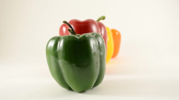 Green, Red, Yellow and Orange Peppers Against White - Arranjo de linha - Dolly Left — Vídeo de Stock