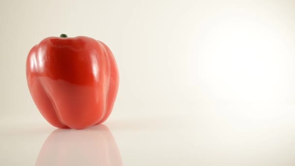 Roterande röd paprika på akryl mot vit - dolly vänster — Stockvideo