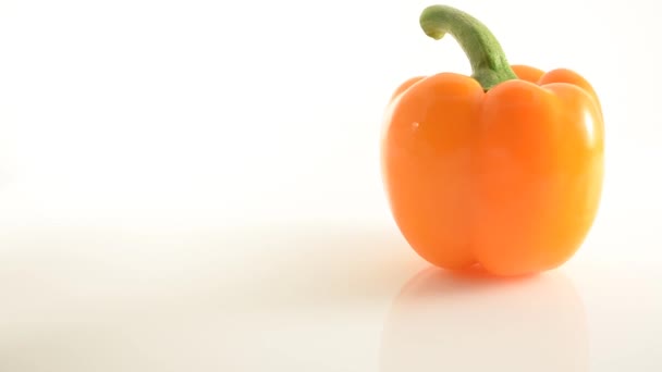 Poivre orange rotatif sur acrylique contre blanc - Grue vers le haut 