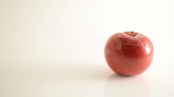 Rotierender Mcintosh-Apfel auf Acryl gegen Weiß - Kran nach unten — Stockvideo