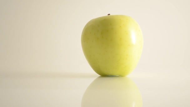 Rotazione Golden Delicious Apple su acrilico contro il bianco - Dolly sinistra — Video Stock