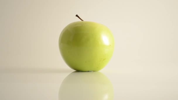 Granny smith apple op acryl tegen Wit - dolly rechts roteren — Stockvideo