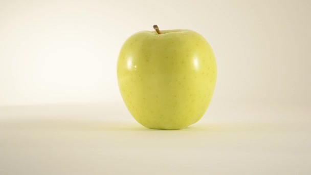 Περιστρεφόμενες χρυσή νόστιμα apple ενάντια στο λευκό - κουκλίτσα δικαίωμα — Αρχείο Βίντεο