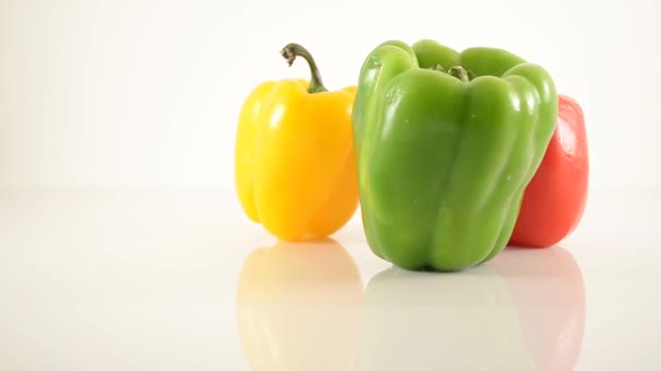 Green, Red, and Yellow Peppers On Acrylic Against White - Triangle Arrangement - Dolly Left — Stock Video