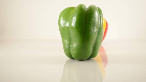 Grüne, gelbe und rote Paprika auf Acryl gegen weiße - Linienanordnung - Dolly links — Stockvideo