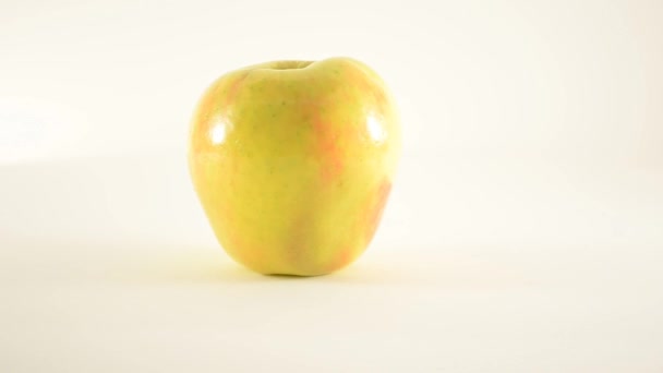 Обертається медоносний яблуко проти білого Доллі ліворуч — стокове відео