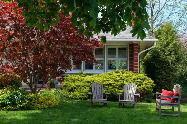 Sedie da giardino di fronte a una casa Fotografia Stock