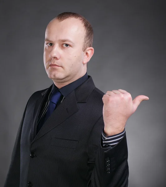 Serious young businessman pointing at something — Stock Photo, Image