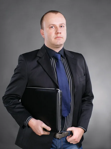 Portrait of a young business man standing with laptop — Stock Photo, Image