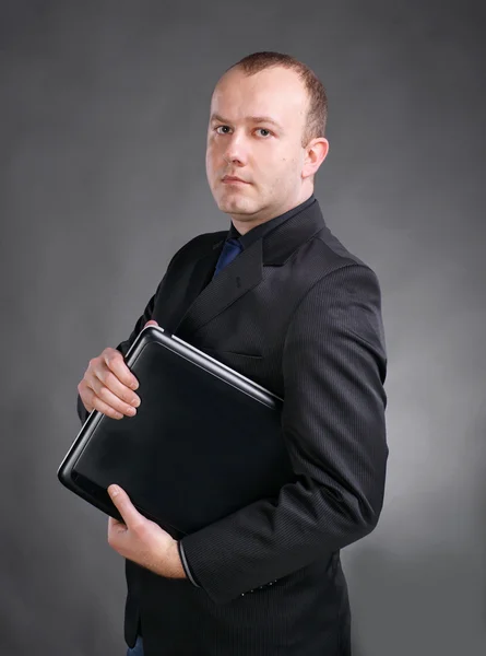 Portrait of a young business man standing with laptop — Stock Photo, Image