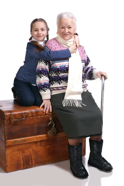 Old woman sitting on a box with her granddaughter — Stock Photo, Image