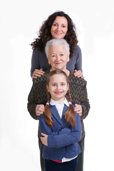 Row of little girl, grandmother, mother looking at camera in lin — Stock Photo, Image