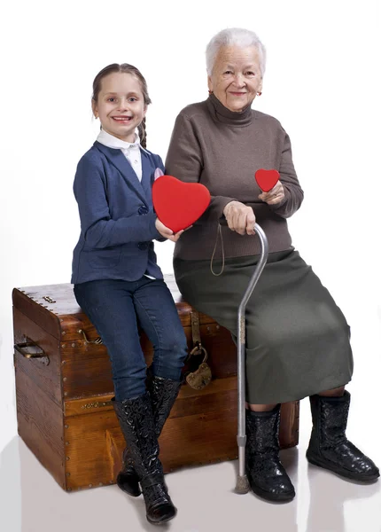 Grandmother and granddaughter holding hearts — Stock Photo, Image