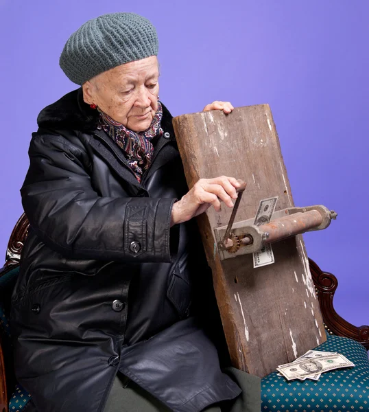 Stará žena lisování peníze — Stock fotografie