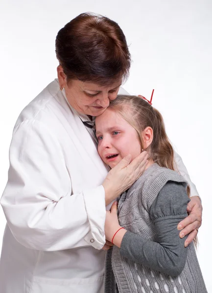 Pediatra sênior acalmando menina — Fotografia de Stock